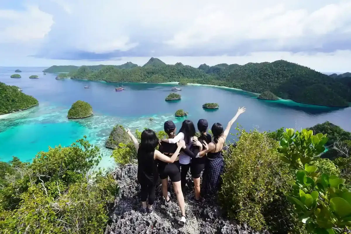 A small group celebrating on a Raja Ampat viewpoint